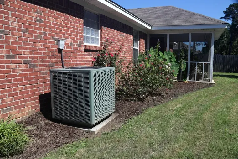 A brick house with an air conditioner on the side of it