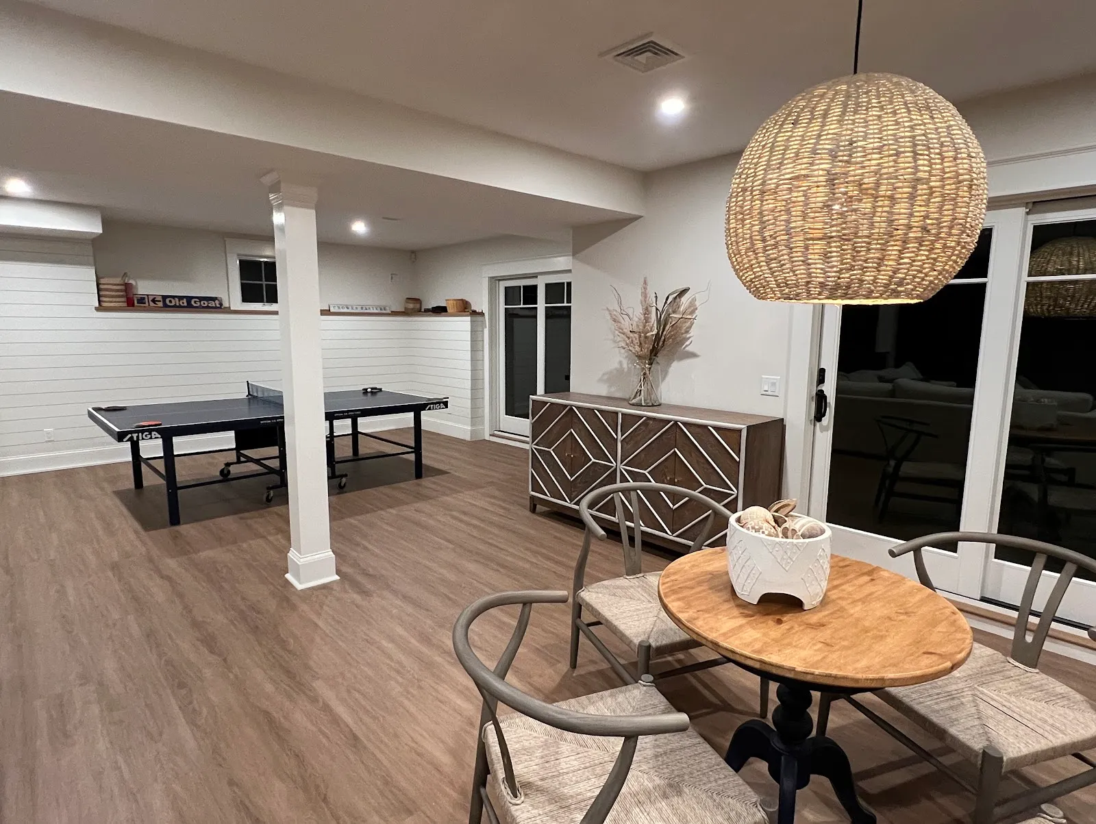 Finished lower-level game room with shiplap and wide-plank flooring