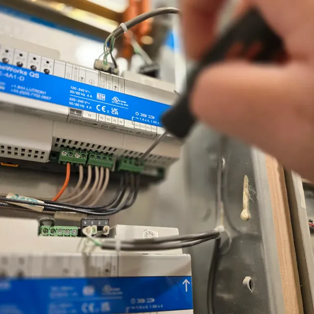 Close-up of a technician wiring a lighting control module