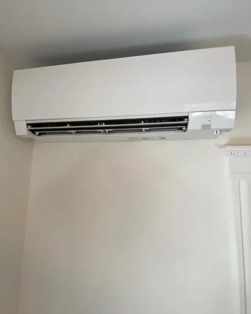 a white air conditioner is hanging from the ceiling in a room
