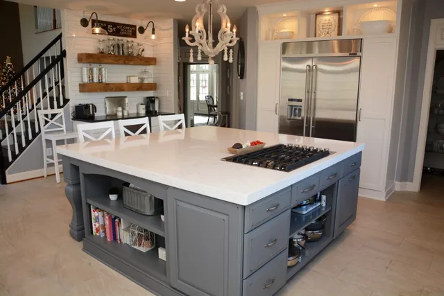 Large grey painted island with open shelving and quartz top
