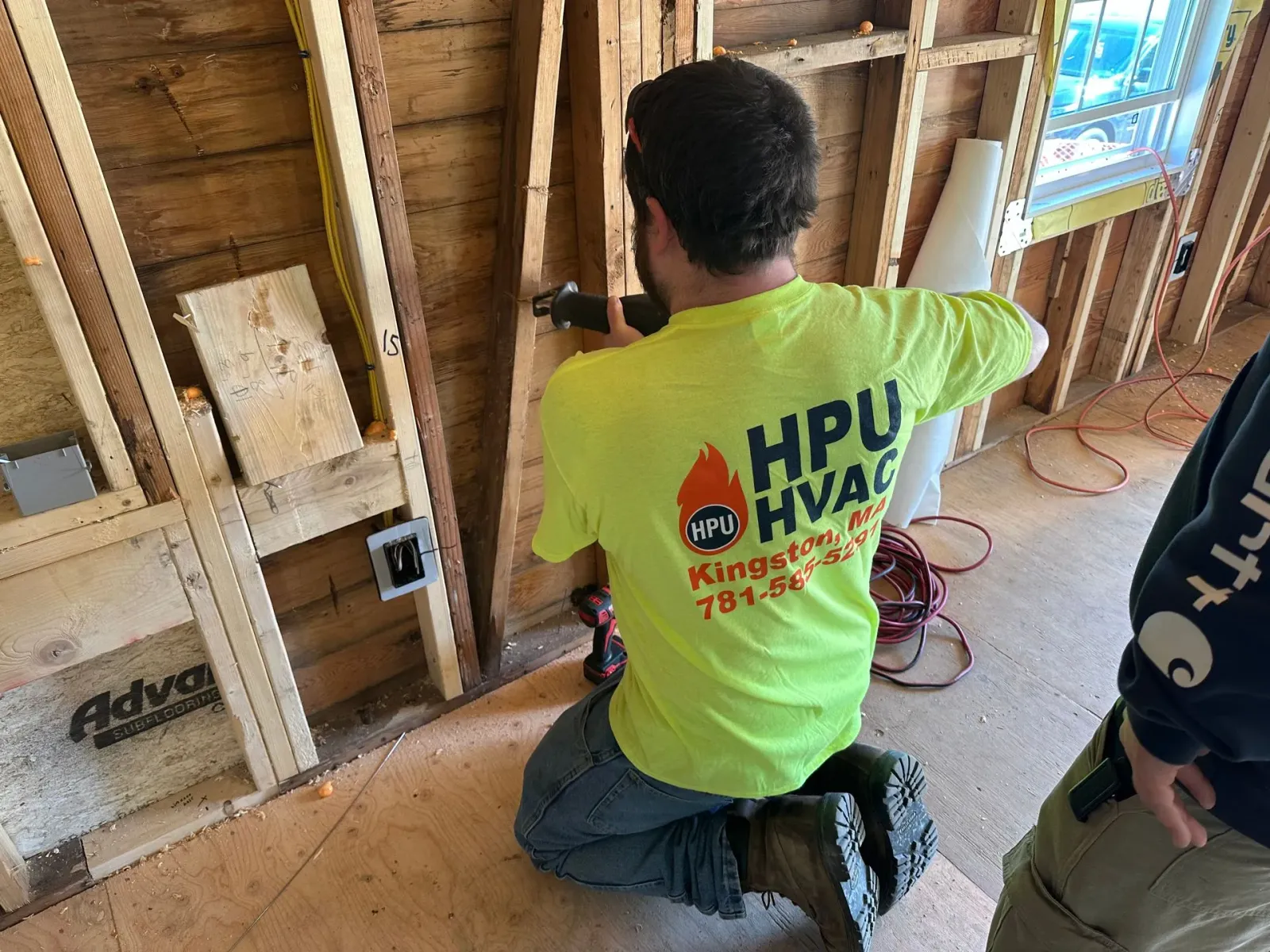 A man is cutting a wall for an air conditioner