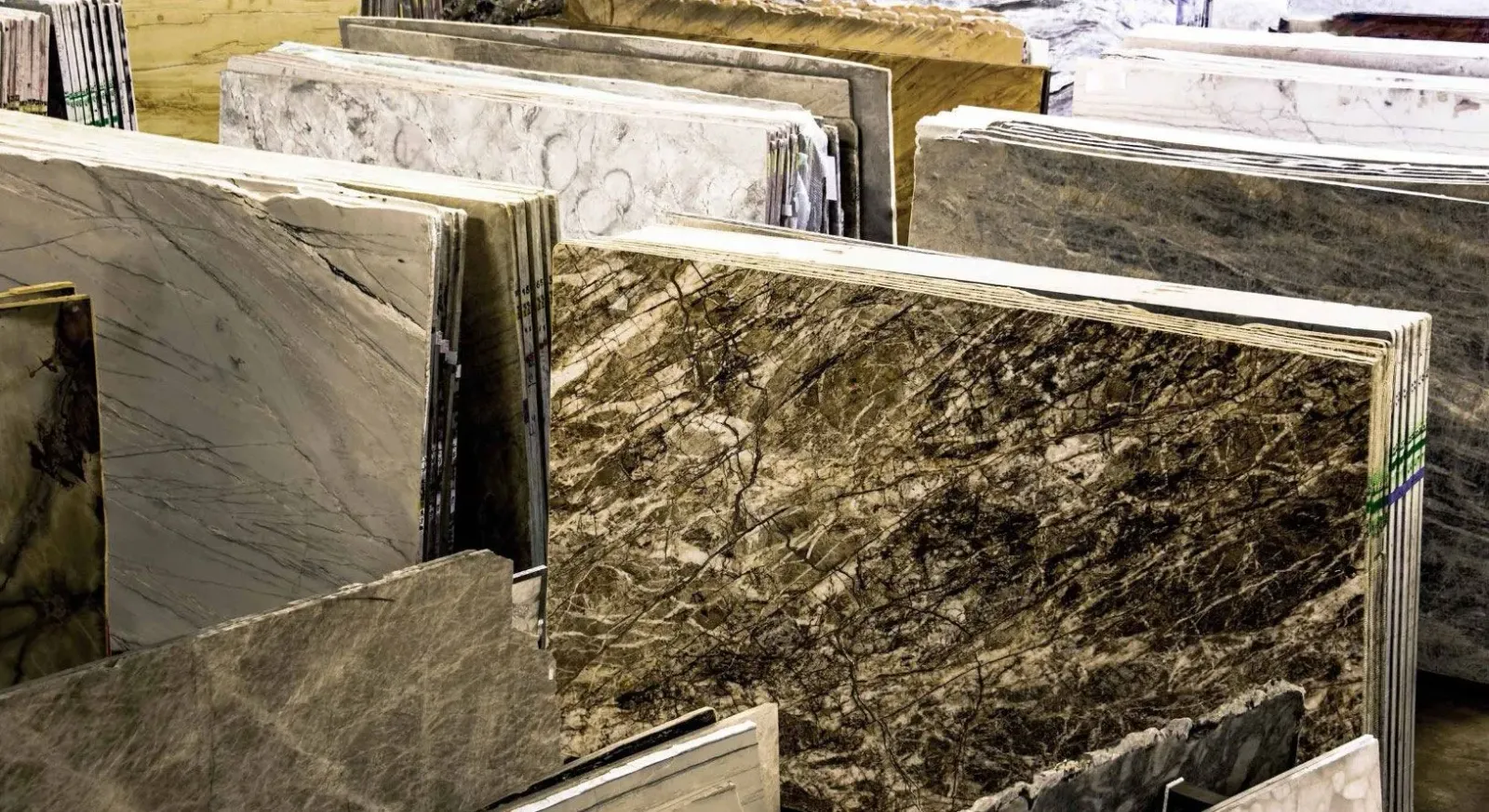 A bunch of marble slabs are stacked on top of each other in a warehouse