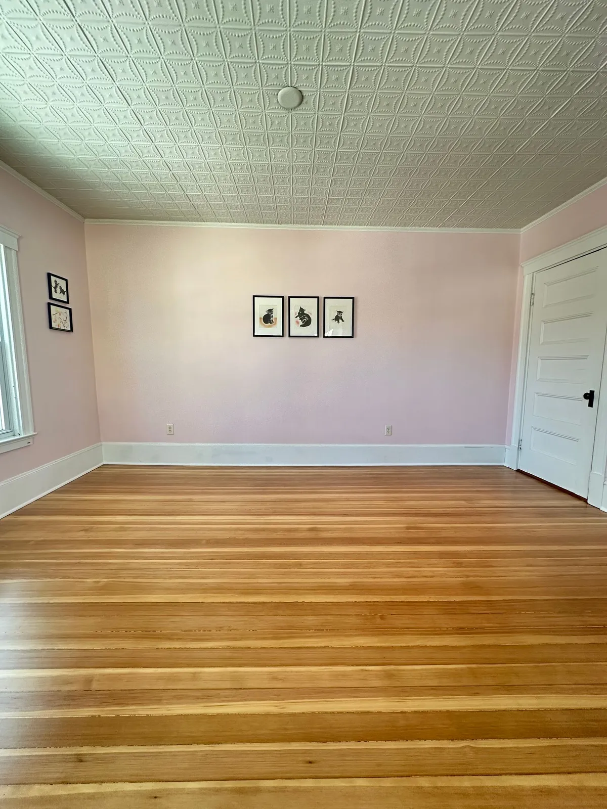 Refinished hardwood floor under a pressed-tin ceiling