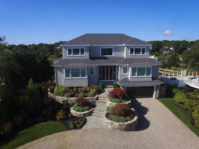 Large home with stone driveway, lower level garage, teired stairway