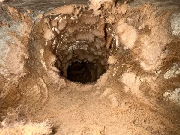 Air duct branch takeoff packed with lint and dust before cleaning