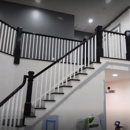 Interior painting and trim — crisp white walls with black-finished staircase railings
