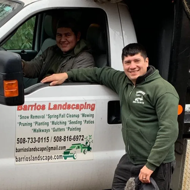 Image of owner barrios landscaping leaning on truck with company info