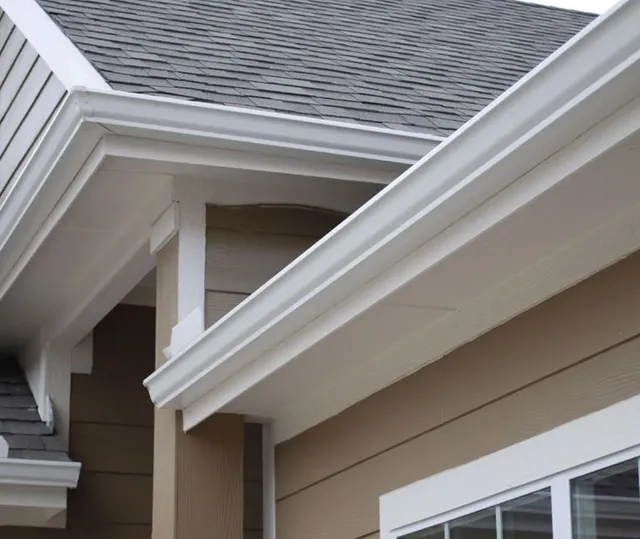 Newly installed white gutters along a home's roofline