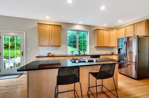 Kitchen with maple cabinets and black countertops
