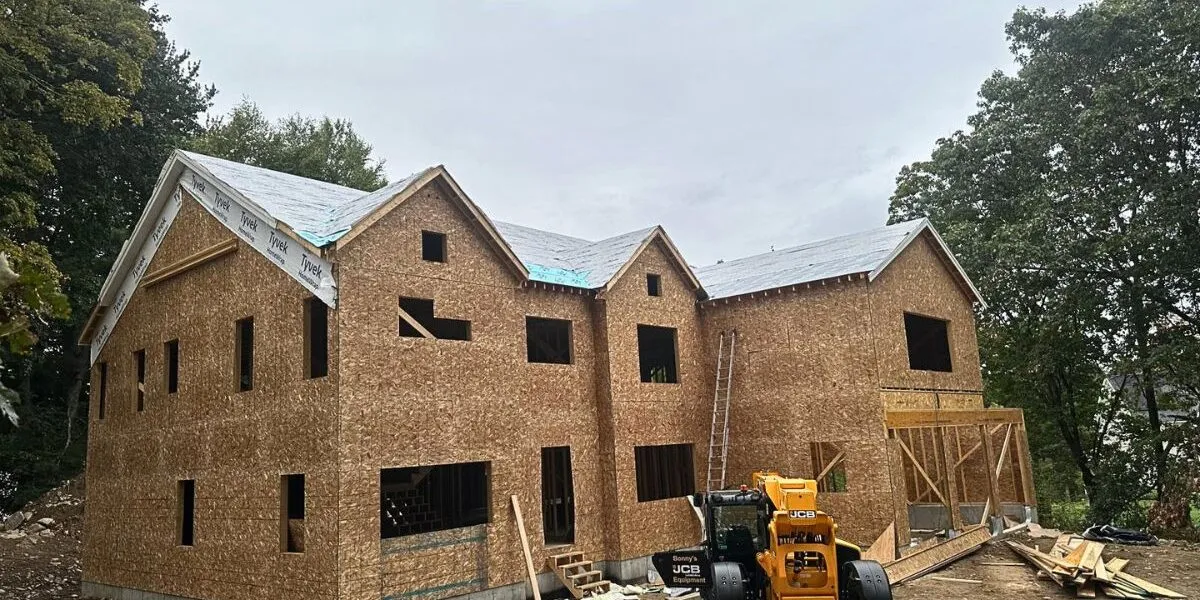 Large-scale custom home framing and roof underlayment installation project with JCB equipment in Sudbury MA