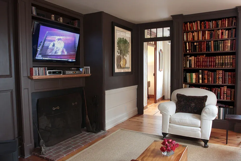 Restored paneled living room with built-in bookcases