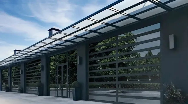 Four glass garage doors with red trim and yellow bollards, set in a modern building.