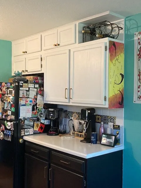 new cabinet hardware and additional row of cabinets and a cubby above upper kitchen cabinets