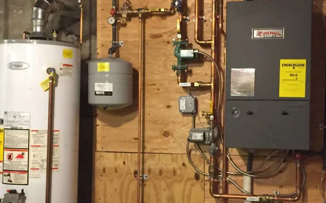 A water heater and a boiler are connected to a wall