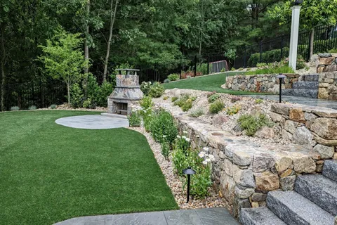 natural stone masonry, artificial turf lawn, Natural stone fireplace, concrete pavers, Natural Granite steps hand chiseled on site, Paver walkways, landscape design services
