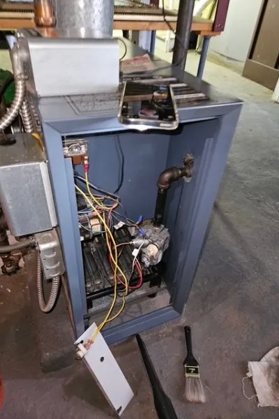 Open furnace with exposed wires and tools