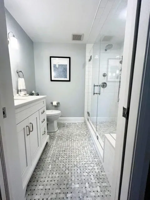 Contemporary bathroom with glass shower, white vanity, and minimalist decor.