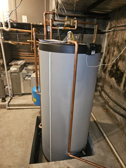 New indirect water heater installed in the same recessed pit with copper piping