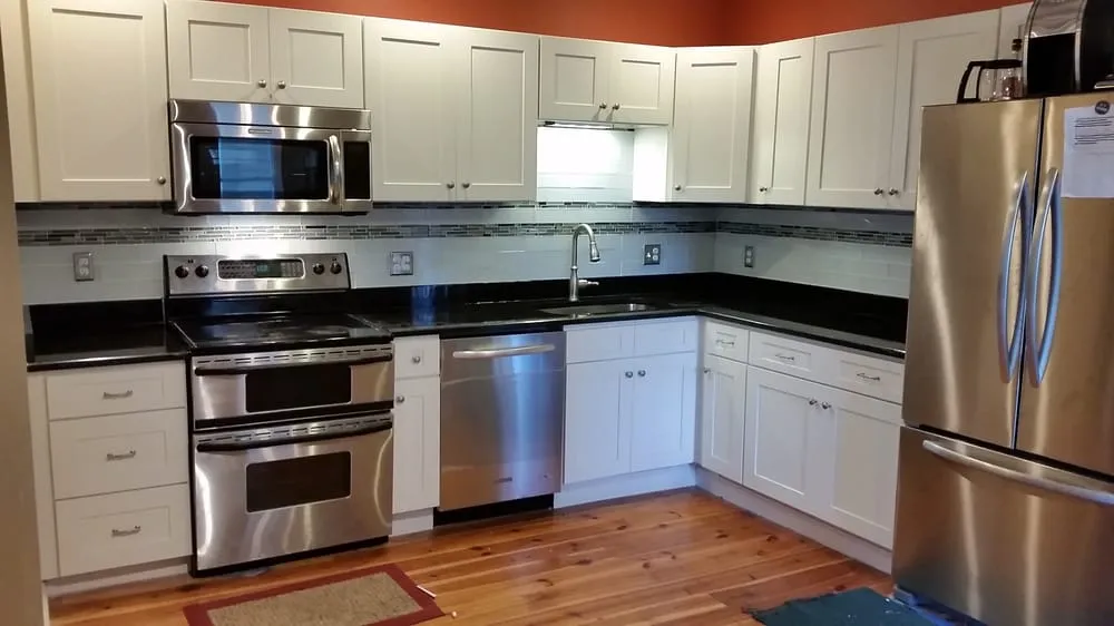 Renovated kitchen with shaker cabinets and glass tile backsplash