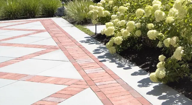 Geometric brick and stone paving pattern with hydrangea planting