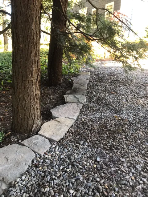 Native Goshen Stone edging cobbles define driveway, lawn and gardens