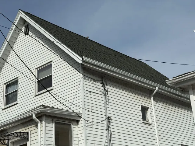 A white house with a black roof and windows