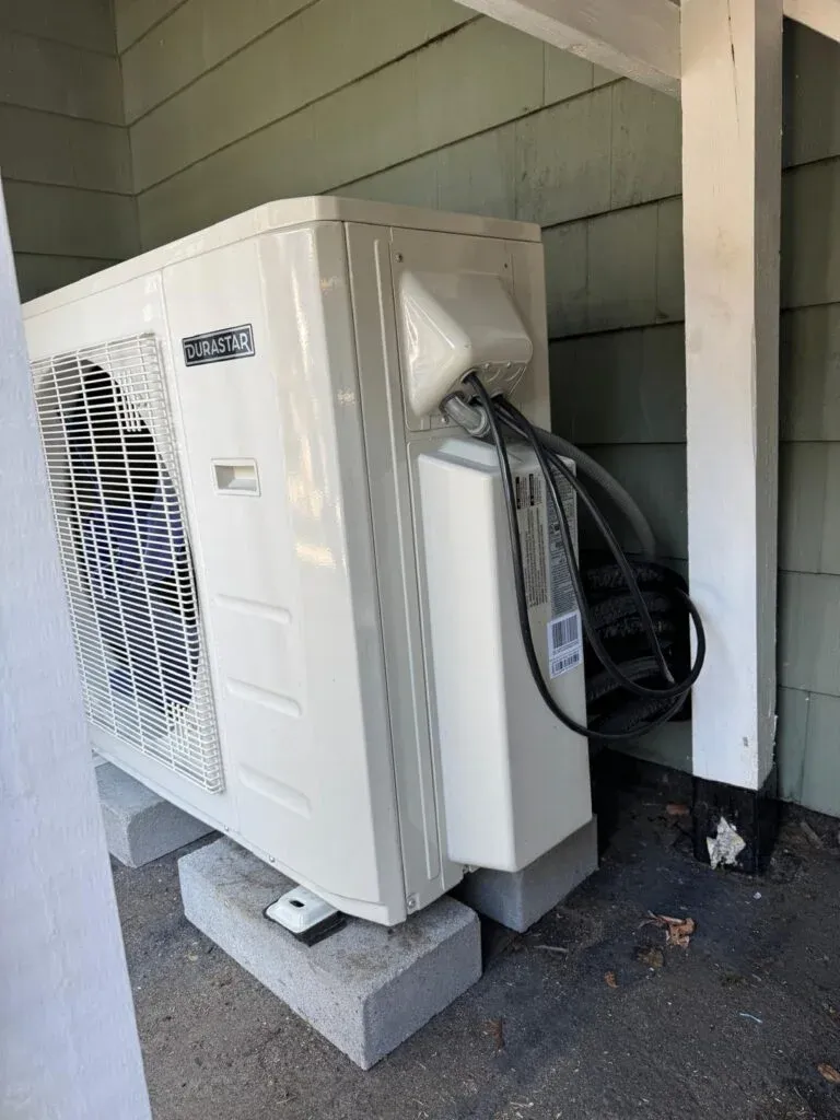 Durastar outdoor heat pump condenser unit installed on a porch