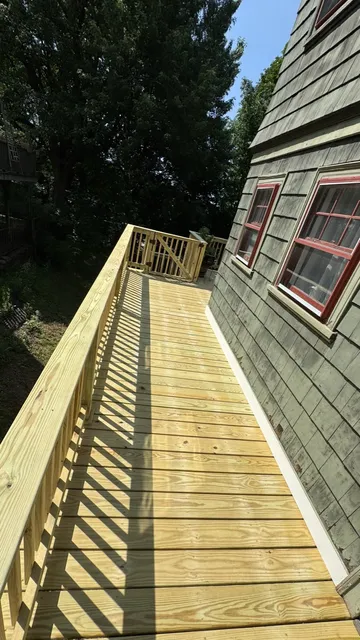 Long pressure-treated elevated walkway along a shingled house