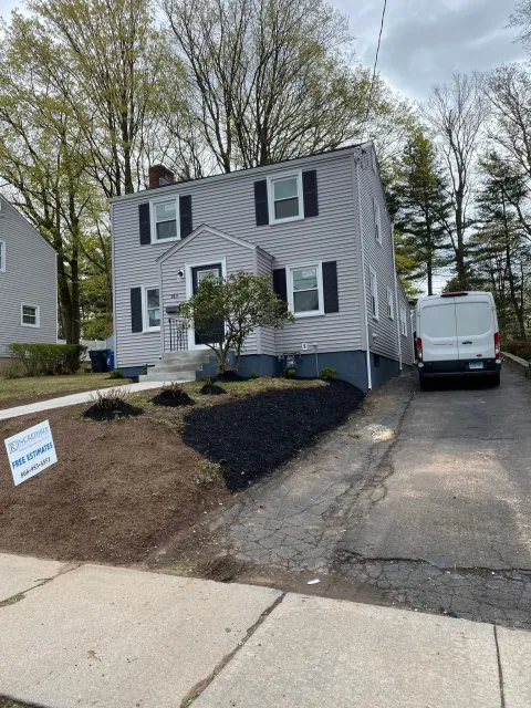 A white van is parked in front of a house.