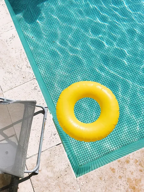 Yellow float drifting on calm pool water