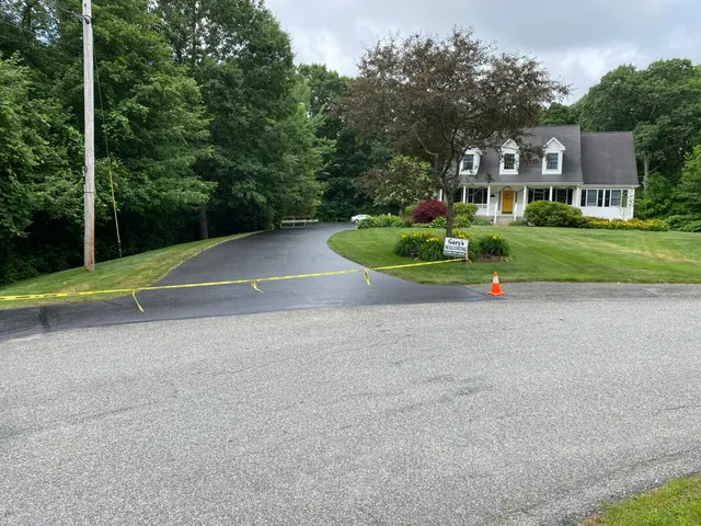 A driveway with a house in the background