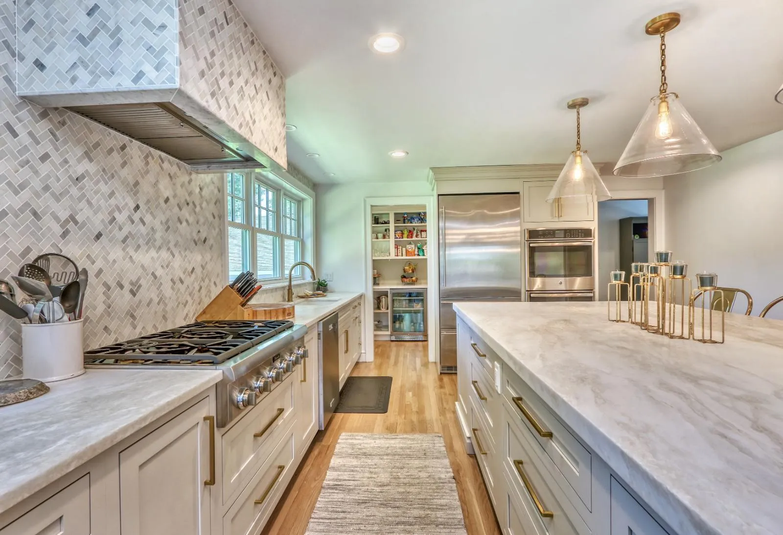 Bright kitchen renovation in Melrose, MA by PEGASUS Design-to-Build showcasing quartz countertops and brass fixtures.-optimized