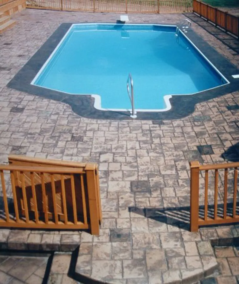 Stamped concrete pool deck with brick paver surround