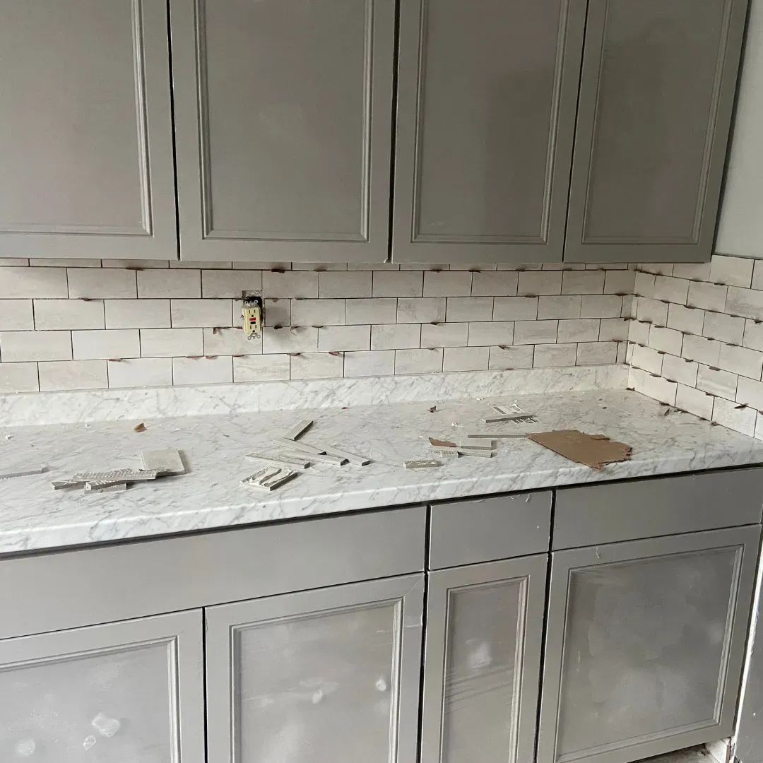 Kitchen remodel in progress with Carrara marble counter and gray cabinets, subway tile ba by SF Construction in Worcester, MA