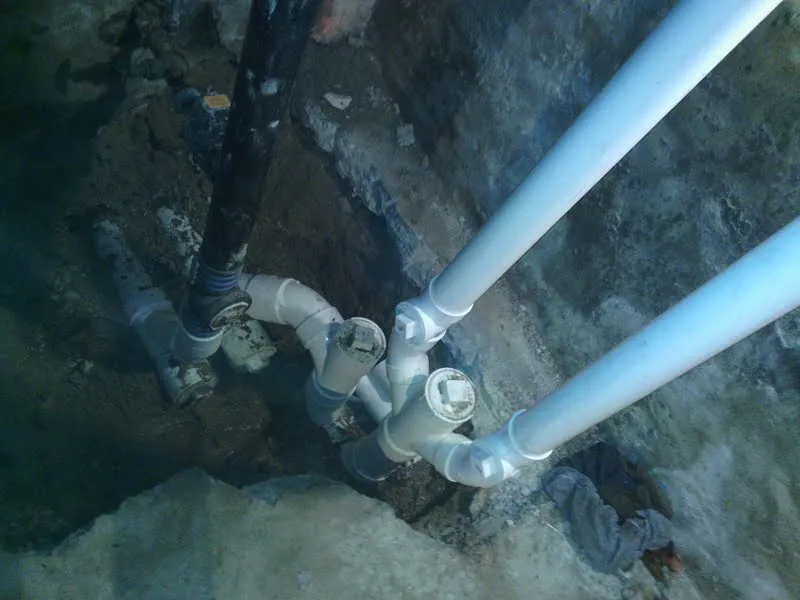 Close-up of new PVC drain fittings in an open trench