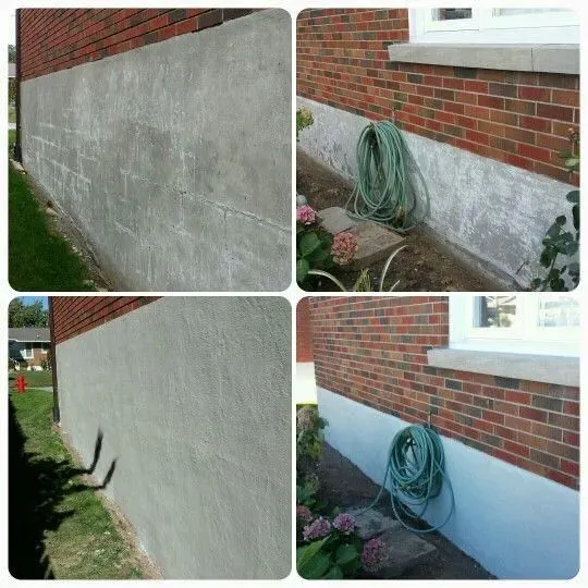Brick house exterior with damaged gray stucco foundation and a coiled green hose by the wall.