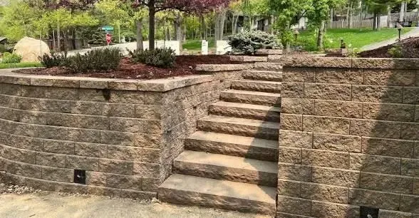 Stone staircase built into a retaining wall in a landscaped garden.