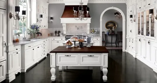 A kitchen with white cabinets and a large island in the middle.