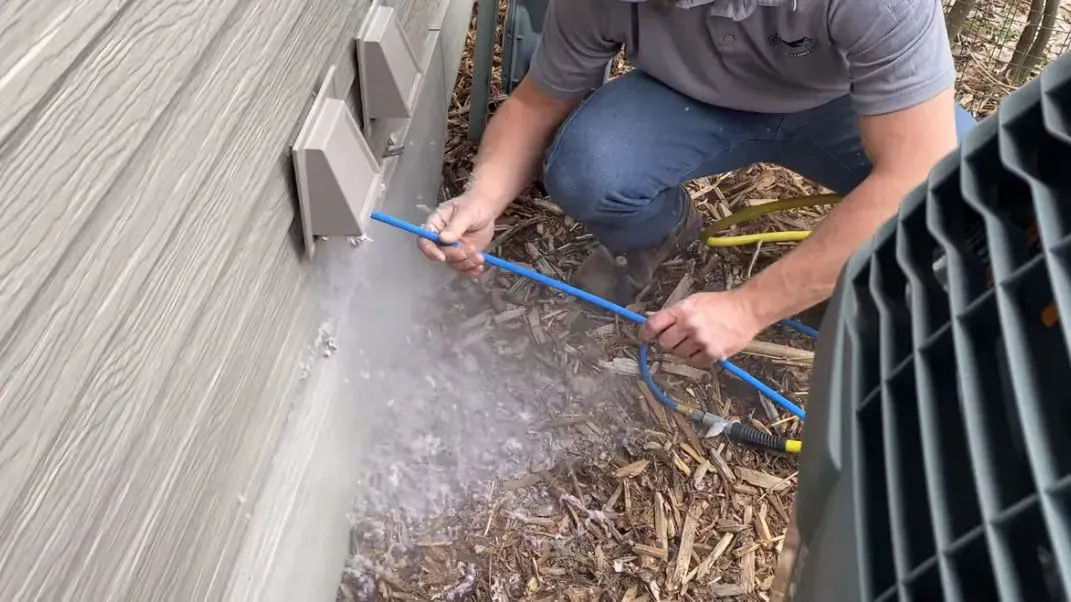 A dryer vent tech cleaning a vent.