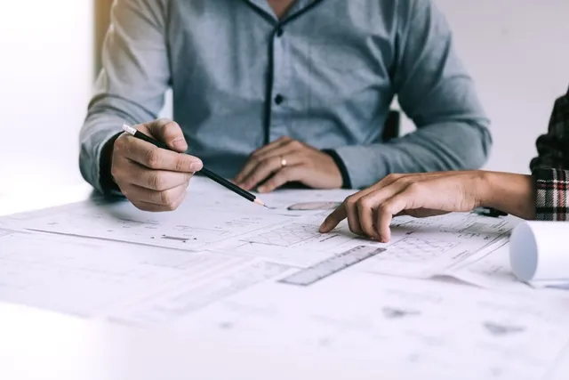 Image of two people consulting at a desk