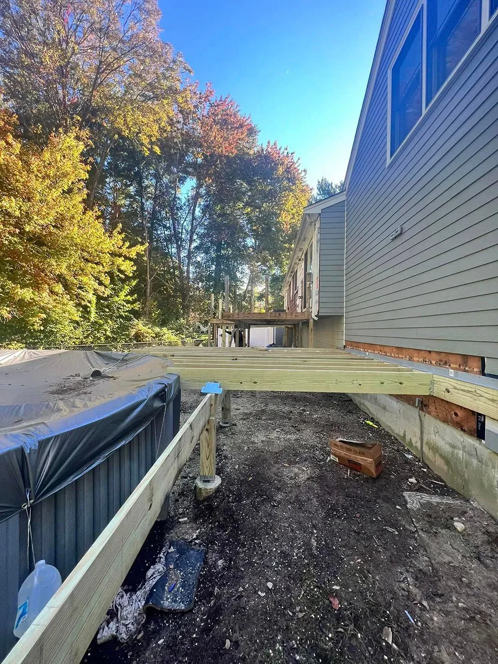 A wooden deck is being built next to a house