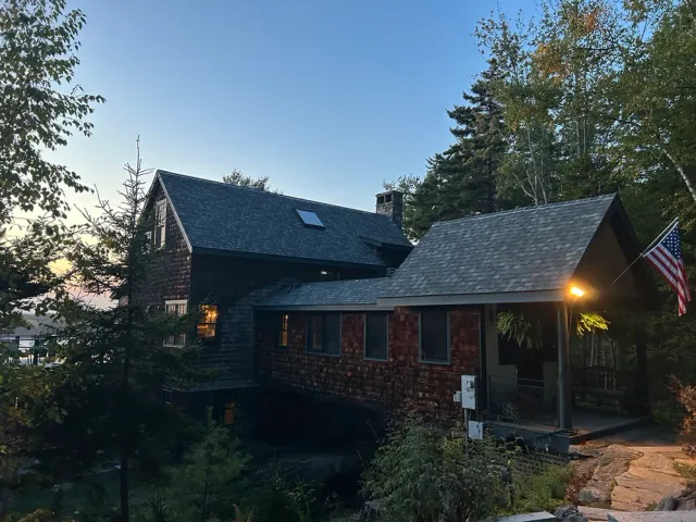 Waterfront house at dusk with an American flag