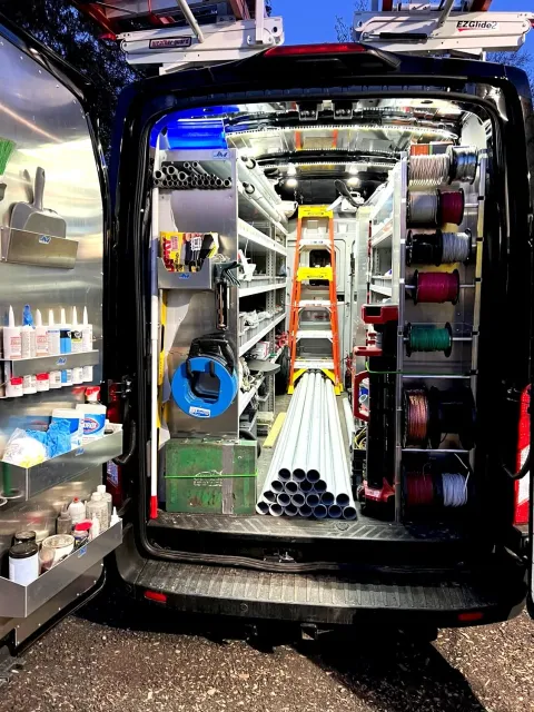 One of our vans, open showing all of the tools, wire etc. inside