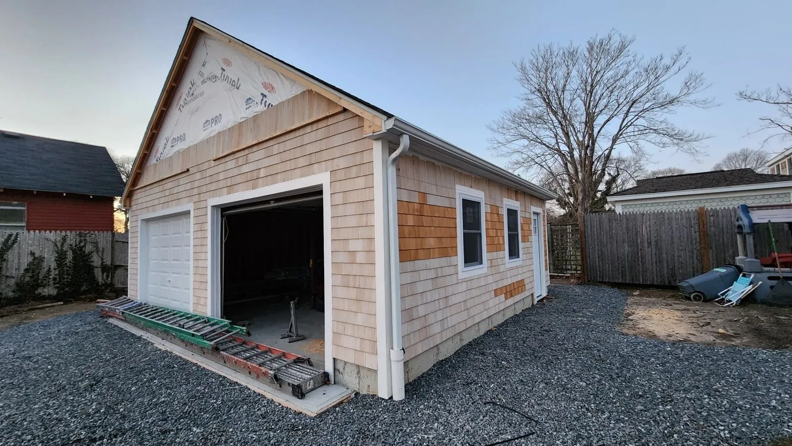 Garage clad in cedar shingle siding with new gutters installed