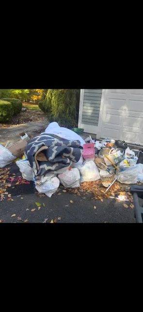 Bags, rolled rugs and household items gathered outside a garage