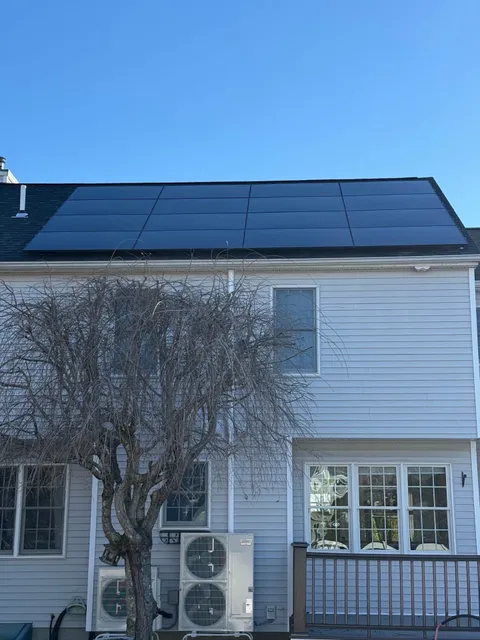 Close view of a flush-mounted all-black solar array on a residential shingle roof
