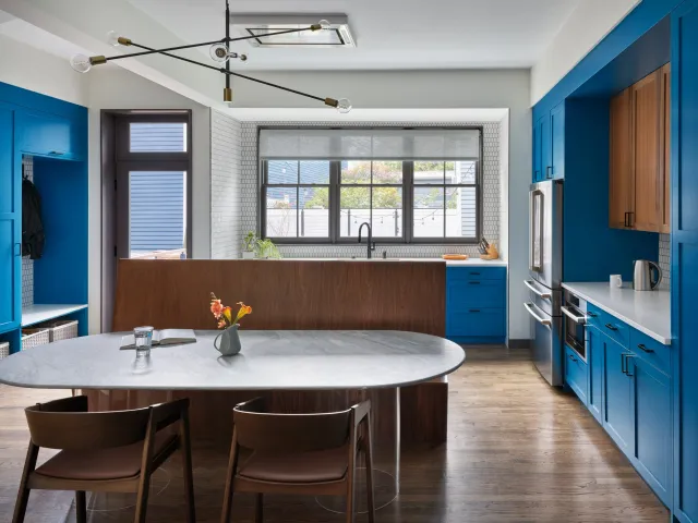 Modern mud room and kitchen with a custom bench and bight blue cabinets