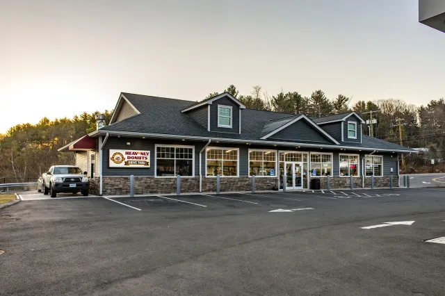 Heavenly Donuts restaurant exterior with a parking lot and drive thru with a red awning.