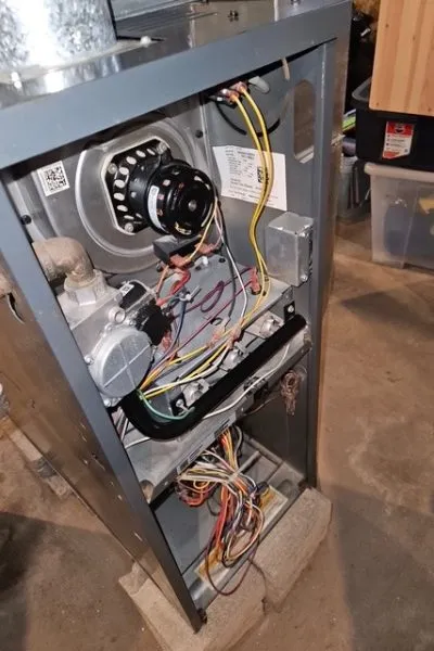 Open residential gas furnace with visible wiring